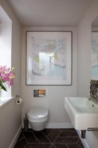 a bathroom with a white toilet and a sink at Horsepool Boathouse in Salcombe