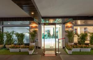 an entrance to an office building with potted plants at The Ashtan Sarovar Portico in New Delhi