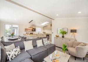 a living room with a gray couch and a kitchen at C03 - The Faraday in Bangor