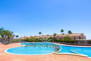 uma grande piscina num resort com palmeiras em Breathtaking Panoramic Views in Golf del Sur em San Miguel de Abona
