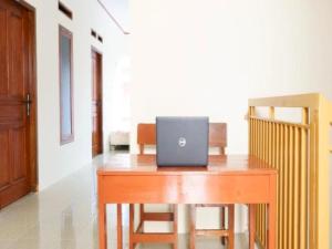 un computer portatile seduto sopra una scrivania in legno di OYO 93249 Wisma Jasmine Syariah a Kuningan