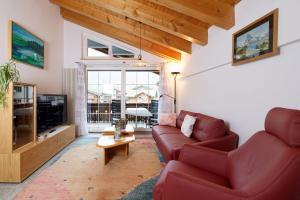 een woonkamer met een rode bank en een tafel bij Apartments Aura in Zermatt