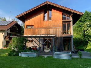 a large wooden house with a green yard at Ferienhaus Haslberger in Waging am See