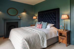 um quarto com uma cama grande e um espelho em Hummingbird House em Holbeton
