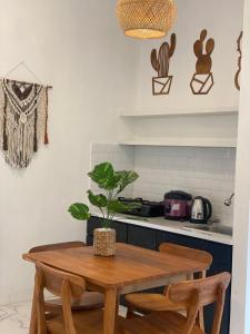 eine Küche mit einem Holztisch und einer Topfpflanze darauf in der Unterkunft Emerald Guest House type kansas Purwokerto in Banyumas