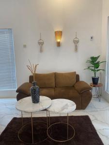 uma sala de estar com um sofá e duas mesas em Emerald Guest House type kansas Purwokerto em Banyumas