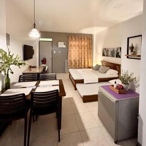 JORA Studio Apartment 1-B في داغوبان: غرفة معيشة مع سرير وغرفة طعام