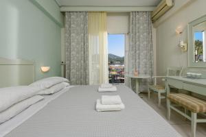 萨索斯Hotel Timoleon的一间带大床的卧室和一间浴室