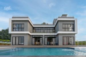 uma casa com uma piscina em frente em Casa Boho by StayVista - Contemporary design, Farm-view, Swimming pool & Indoor games for a chic retreat em Nashik