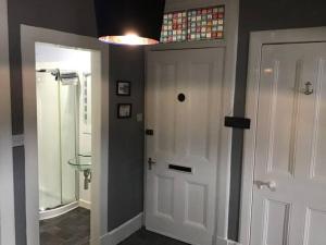 a bathroom with a white door and a walk in shower at Bellevue Bute, Luxury 2 bedroom sea view flat in Rothesay