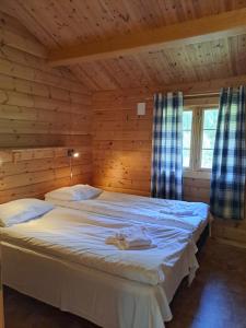 a bedroom with a large bed in a log cabin at Stardalen Hyttegrend in Klakegg