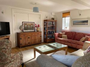 a living room with a couch and a table at Cottages at Woodlands, Appleloft in Wareham