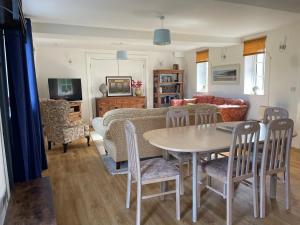 sala de estar con mesa, sillas y sofá en Cottages at Woodlands, Appleloft en Wareham