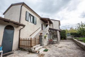 a white house with a blue door and stairs at #914 Home - Irpinia in Nusco