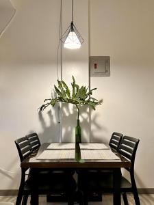 a dining room table with a vase of flowers at JORA Studio Apartment 1-B in Dagupan