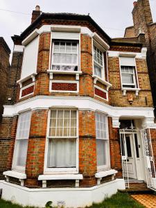 a red brick house with white windows and a door at Victorian Woods BnB in London