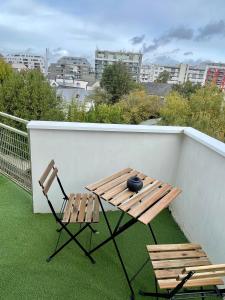 uma varanda com 2 cadeiras, uma mesa e um vaso em La Cabane Rennaise em Rennes