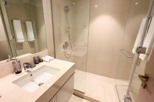 een witte badkamer met een wastafel en een douche bij MH - Act Tower - Burj View - 2BHK - Ref 410 in Dubai
