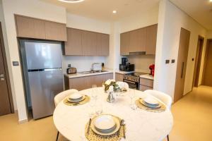 een keuken met een tafel met stoelen en een koelkast bij MH - Act Tower - Burj View - 2BHK - Ref 410 in Dubai