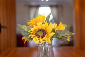 eine Vase voller gelber Sonnenblumen auf einem Tisch in der Unterkunft Abbey Farm House Ormskirk in Ormskirk
