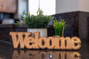 a wooden sign that sayswwinyl on a counter with plants at Abbey Farm House Ormskirk in Ormskirk