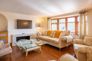 a living room with a couch and a fireplace at Abbey Farm House Ormskirk in Ormskirk