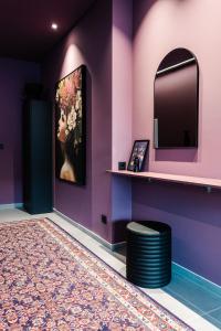 Zimmer mit lila Wänden, einem Spiegel und einem Teppich in der Unterkunft Exklusive Design Appartement BlackBerry Neubau in Pfungstadt