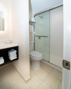 a bathroom with a toilet and a glass shower at Holiday Inn New Orleans West Bank Tower, an IHG Hotel in Gretna