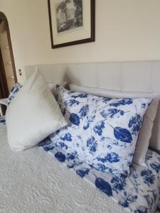 a bed with blue and white sheets and a pillow at Sea view con terrazza e giardino 2 camere doppie 1 singola in Capri