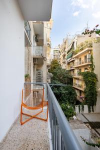 einen Balkon mit orangefarbenem Geländer und einige Gebäude in der Unterkunft Spacious Central Apt Downtown in Athen