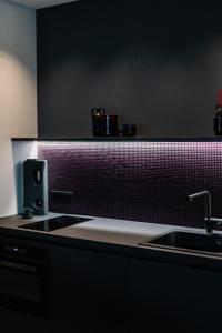 eine Küche mit einer Spüle und einer Arbeitsplatte in der Unterkunft Exklusive Design Appartement BlackBerry Neubau in Pfungstadt