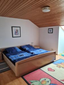 um quarto com uma cama e um tecto em madeira em Ferienwohnung Sonnenblume mit Hallenbad und Sauna em Missen-Wilhams