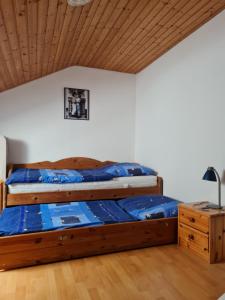 ein Bett mit einem Holzrahmen in einem Zimmer in der Unterkunft Ferienwohnung Sonnenblume mit Hallenbad und Sauna in Missen-Wilhams