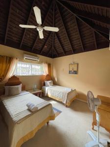 una camera con 2 letti e un ventilatore a soffitto di Peaceful Palms Montego Bay a Montego Bay