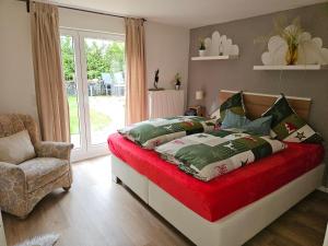 ein Schlafzimmer mit einem Bett, einem Stuhl und einem Fenster in der Unterkunft Haus SauerlandLiebe in Schmallenberg
