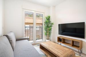 een woonkamer met een bank en een flatscreen-tv bij apartamentos en vallecas in Madrid