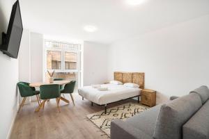een woonkamer met een bed, een tafel en een bank bij apartamentos en vallecas in Madrid