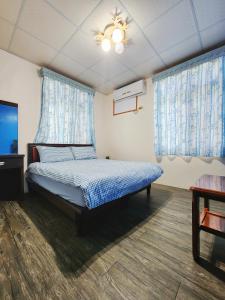 a bedroom with a bed and a tv and windows at Hai Yin in Green Island