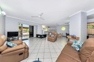 a living room with two couches and a tv at Nightcliff Foreshore Getaway - McKay Gardens in Nightcliff