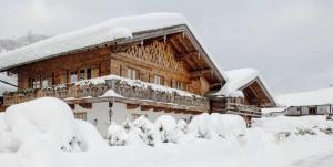 Cabaña de madera con nieve en el techo en Ferienwohnungen Gerold, Kreuth-Reitrain en Oberach