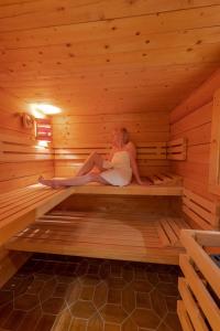 una mujer está sentada en una sauna en Ferienwohnungen Gerold, Kreuth-Reitrain en Oberach