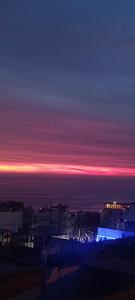 una vista de la ciudad por la noche con el cielo en Sunrise Hostel Taghazout en Taghazout