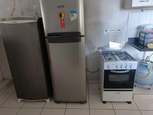 a refrigerator and a stove in a kitchen at Casa de Temporada Meaipe in Guarapari
