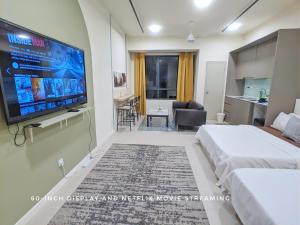a bedroom with a large flat screen tv on the wall at Tamarind Suites OR Domain NeoCyber, click room first for pics in Cyberjaya