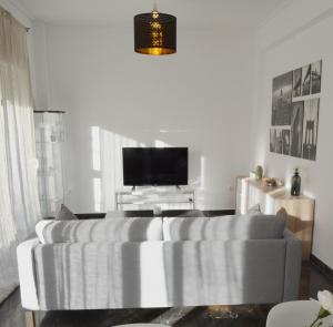 un soggiorno con divano e TV a schermo piatto di Gtrip P Faliro Coastal Comfort 2F ad Atene