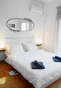 a bedroom with a white bed with two towels on it at Gtrip P Faliro Coastal Comfort 2F in Athens