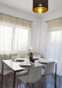 una sala da pranzo con tavolo e sedie bianchi di Gtrip P Faliro Coastal Comfort 2F ad Atene