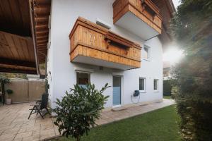 a white building with a wooden balcony on it at CATO Ferienhaus in Kiefersfelden