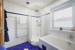 a white bathroom with a tub and a shower at CATO Ferienhaus in Kiefersfelden