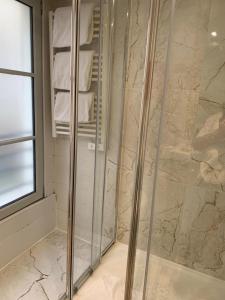 bagno con doccia in vetro e asciugamani di 42-LUXURY FLAT a Parigi
